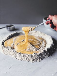 a person is mixing some food in a bowl with a spatula on top of it