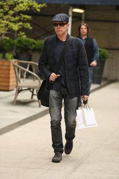 a man walking down the street carrying shopping bags