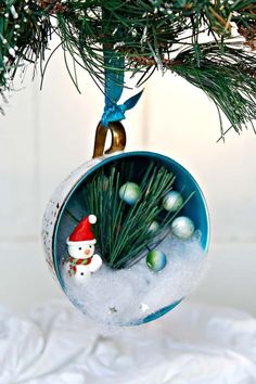 an ornament hanging from a christmas tree with snow and ornaments in the background