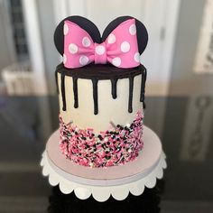 a minnie mouse cake decorated with pink and white sprinkles