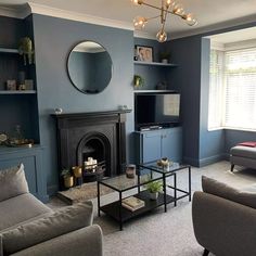 a living room filled with furniture and a fire place in front of a tv mounted on a wall