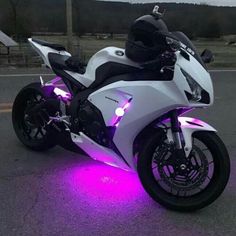 a white motorcycle with purple lights on it