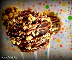 two chocolate covered cookies on top of each other with sprinkles and nuts