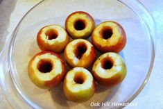 several apples are in a glass bowl on a counter top, ready to be eaten