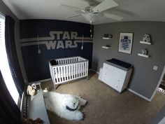 a baby's room with a star wars theme painted on the wall and white furniture