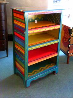 a multicolored wooden book shelf with lots of books on it's shelves