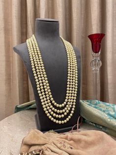 We are proud of our prestigious heritage in this 4 strand pearls groom mala for the bridegroom! A necklace that upholds traditions is royal and elegant. Perfect for the grooms to pair with their sherwanis. Details: Length of Necklace-14.5 Inches All products are manufactured using traditional skills from our rich heritage of crafts.  The process of these crafts is essentially manual. Hence, any irregularities or variations are an inherent part of these handcrafting processes. Bollywood Style Pearl Necklace For Formal Festivals, Formal Bollywood Pearl Necklace For Festivals, Gold Kundan Mala With Polished Beads, Pearl Bridal Necklace For Reception During Diwali, Pearl Bridal Necklace For Reception At Diwali, Traditional Pearl Necklace For Formal Festive Occasion, Traditional Pearl Bridal Necklace For Reception, Elegant Wedding Beads For Diwali, Traditional Pearl Chain Beads For Festive Occasion