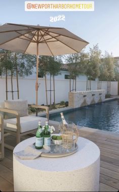 a table with drinks and bottles on it next to a pool