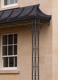 an open window on the side of a building with a black awning over it