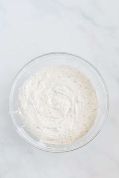 a bowl filled with white sauce sitting on top of a table