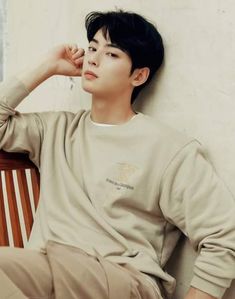 a young man sitting on top of a wooden bench