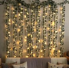 a living room filled with lots of lights and greenery hanging on the side of the wall