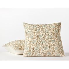 two pillows sitting next to each other on a white surface