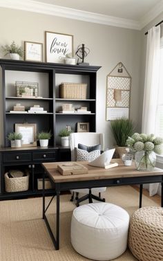 a home office with black bookcases and white accessories on the desk, along with a round ottoman