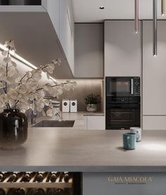 a modern kitchen with stainless steel counter tops and white cabinetry, along with a vase filled with flowers