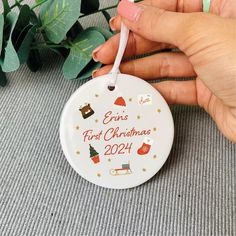 someone is holding a personalized ornament for the first christmas in their home