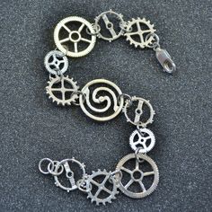 "A mechanical manifestation of your interest in steampunk, my gear bracelet in sterling silver is made to clasp your wrist as you boldly go forth on your daily adventures. This bracelet is constructed with 5 different gears linked together with soldered jump rings in a line. This bracelet uses 2 different wheels, 1 escape wheel, 1 balance wheel and 1 flywheel. These gears are all cast using the lost-wax process. The total length of this bracelet is 8\". The individual gears range from 1/2\" (9 m Silver Metal Bracelet With Custom Hardware, Steampunk Silver Bracelet As Gift, Silver Steampunk Bracelet As Gift, Silver Steampunk Bracelet For Gift, Silver Stainless Steel Jewelry With Custom Hardware, Silver Bracelet With Custom Hardware, Steampunk Fashion Women, Gear Ring, Arm Temporary Tattoos