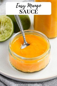 an orange sauce in a glass jar with a spoon next to it on a white plate