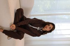 Brunette woman sitting on the couch in a matching lounge set - made up of a brown hoodie and brown sweatpants. Oversized Top, Jogger Sweatpants, Jet Set, High Performance, Espresso, Dark Brown, Lounge Wear, Sweatpants