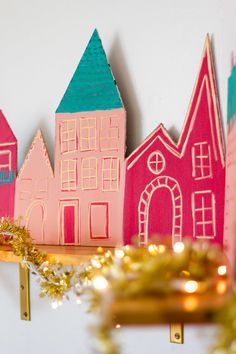 some paper houses are sitting on a shelf