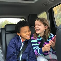 two children sitting in the back seat of a car