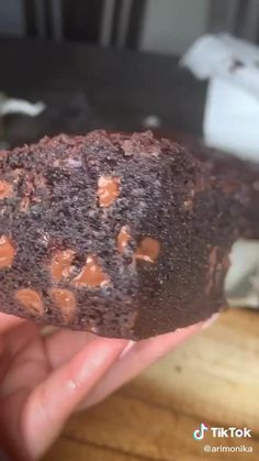 there is a piece of chocolate cake on the cutting board with a spoon in it