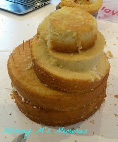 a stack of cakes sitting on top of a white table next to a laptop computer