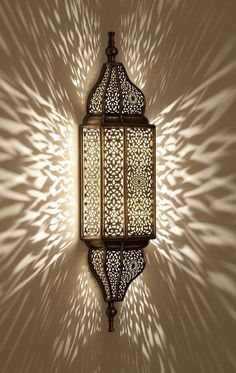 an intricately designed wall light casts a shadow on the wall