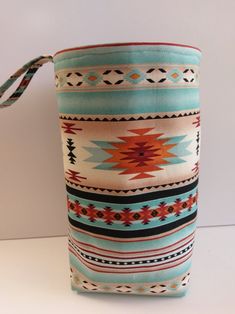 a bag with a colorful pattern on the side and a tassel hanging from it