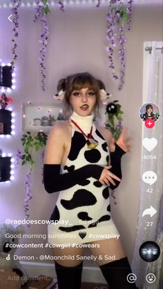 a woman in a cow print dress posing for the camera with her hands on her hips