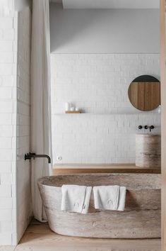 an old bathtub in the middle of a bathroom with white brick walls and floors