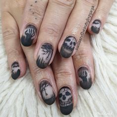 a woman's hand with black and white nail art designs on her nails,