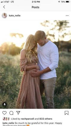 a pregnant couple standing in tall grass at sunset