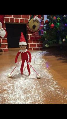 an elf is skating on the floor in front of a christmas tree