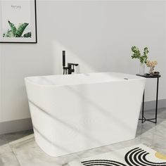 a white bathtub sitting on top of a tiled floor next to a black and white rug