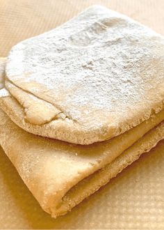 three pieces of bread are stacked on top of each other, with powdered sugar covering them