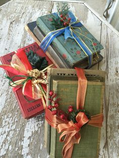 three books with ribbons tied around them sitting on a table