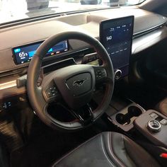 the interior of a car with steering wheel, dashboard and touchscreens on display