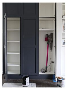 an open closet with paint and tools on the floor next to it, in front of a white wall