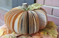 an origami pumpkin sitting on top of a pile of books