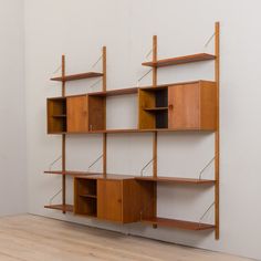 an empty room with shelves on the wall and wood flooring in front of it