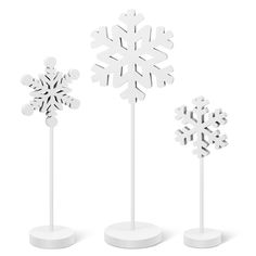 three snowflakes are standing on white bases