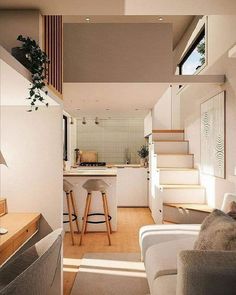 a living room filled with furniture next to a kitchen