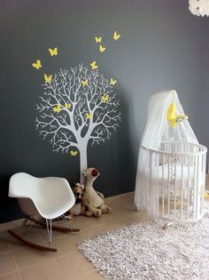 a baby's room with a tree painted on the wall