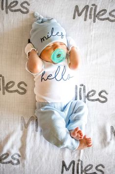 a baby laying on top of a bed wearing a pacifier