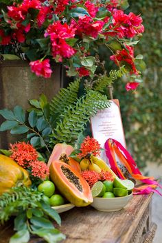 various fruits and flowers on a wooden table