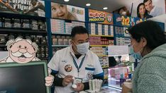 a man wearing a face mask while standing next to a woman in a pharmacy shop