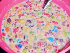 a pink bowl filled with cereal on top of a table