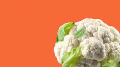 a head of cauliflower on an orange background