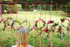 an arrangement of flowers and ribbons on a table in the grass with a fence behind it